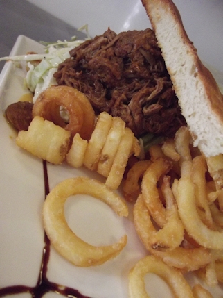Pulled pork sandwich with apple slaw, bbq sauce and curly fries